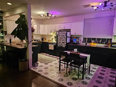 a kitchen with purple lighting and a table and chairs at Tranquility at the House of Alchemy Hollywood in Los Angeles