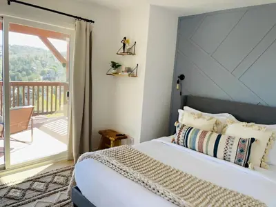 a bedroom with a bed and a balcony at NEW & Luxurious House, hot tub & amazing views in Lake Arrowhead