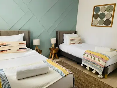 two beds in a room with blue walls at NEW & Luxurious House, hot tub & amazing views in Lake Arrowhead