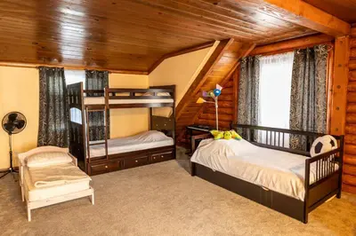a bedroom with two bunk beds and a chair at Pine Mountain Club Family Vacation House in Pine Mountain Club