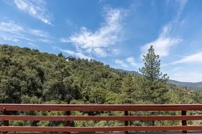 a red bench sitting in front of a hill at Pine Mountain Club Family Vacation House in Pine Mountain Club