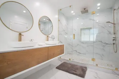 a bathroom with a shower and a sink and a mirror at Universal Studio Stellar Home with pool and jacuzzi in Los Angeles