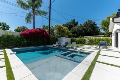 a swimming pool with chairs and a house at Universal Studio Stellar Home with pool and jacuzzi in Los Angeles