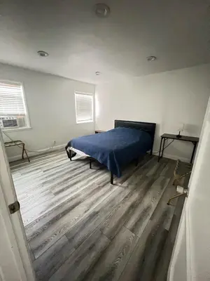 a bedroom with a bed and a wooden floor at Little Bettys Cottage in Torrance