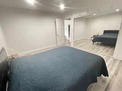 a bedroom with a blue bed and a couch at Little Bettys Cottage in Torrance
