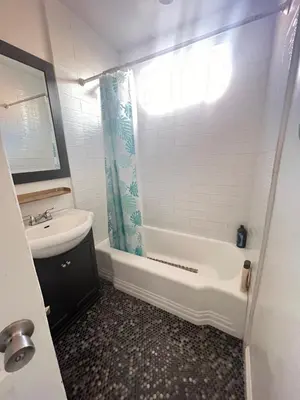a bathroom with a sink and a toilet and a shower at Little Bettys Cottage in Torrance