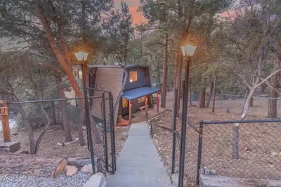 a tree house with two lights on a fence at Stunning Cabin with Private Deck in Big Bear City