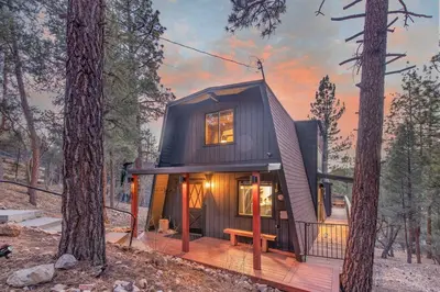 a tiny house in the woods with a porch at Stunning Cabin with Private Deck in Big Bear City