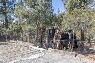 a black truck parked next to a fence at Stunning Cabin with Private Deck in Big Bear City