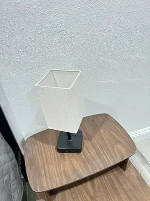 a white lamp on a wooden table next to a bed at Little Betty's Casita in Torrance