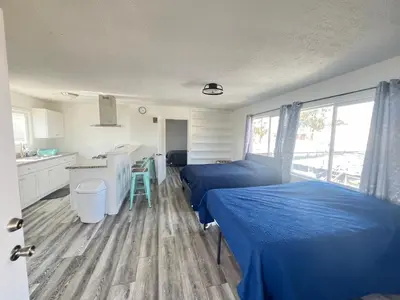 a bedroom with two twin beds and a kitchen at Little Betty’s Hideaway in Torrance