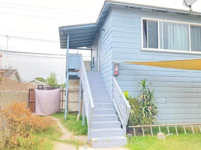 a blue house with a staircase leading up to a house at Little Betty’s Hideaway in Torrance