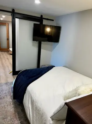 a bedroom with a bed and a tv on the wall at NEW Modern apt w/pool & hot tub in nature in Thousand Oaks
