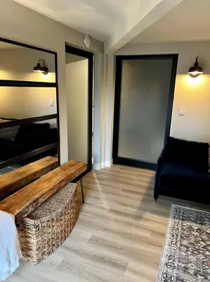 a room with a bed and a bench and a chair at NEW Modern apt w/pool & hot tub in nature in Thousand Oaks