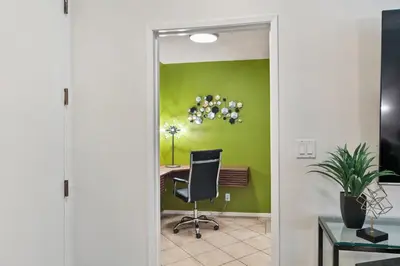 an office with a green wall and a desk with a chair at Beverly Hills Gem 1 BR Apt with Parking 218 in Los Angeles