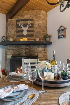 a table with wine glasses and a fireplace at Panoramic Views at Deer Crest Lodge in Lake Arrowhead