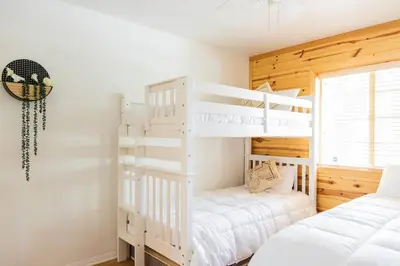 two bunk beds in a bedroom with white at Namu Cabin in Big Bear Lake