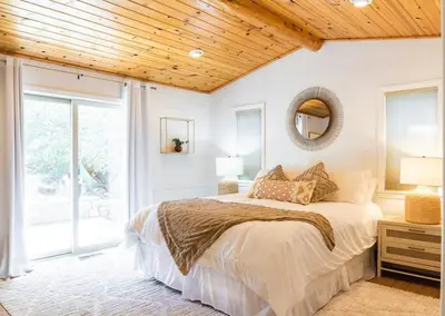 a bedroom with a bed and a wooden ceiling at Namu Cabin in Big Bear Lake