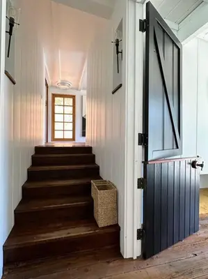 a hallway with stairs with a door and a window at Malibou Lake Oasis in Agoura Hills