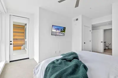 a white bedroom with a bed with a green blanket on it at Ruby Tide - Two Floor Airy 2BR Marina Side Exclusive Amenities in Los Angeles
