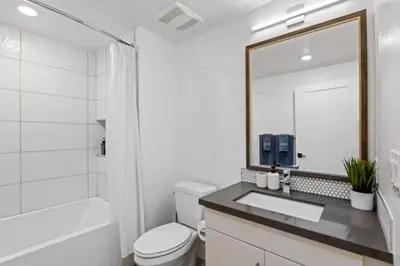 a bathroom with a sink and a toilet and a mirror at Ruby Tide - Two Floor Airy 2BR Marina Side Exclusive Amenities in Los Angeles