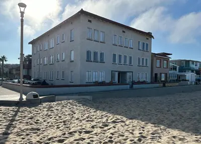 a large building on a sandy beach with a street light at The Vurpillat in Hermosa Beach