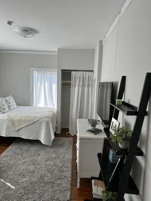 a bedroom with a bed and a desk with a television at The Vurpillat in Hermosa Beach