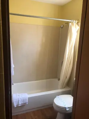 a bathroom with a bath tub and a toilet at Glendora Motel in Glendora
