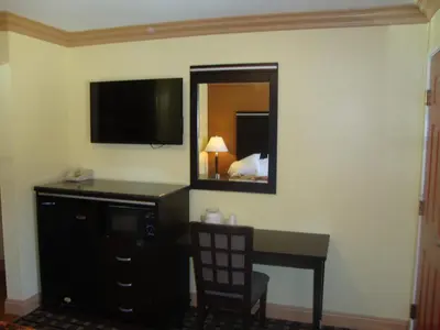 a hotel room with a desk and a mirror at Glendora Motel in Glendora