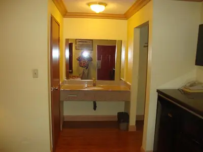 a person taking a picture of a bathroom sink at Glendora Motel in Glendora