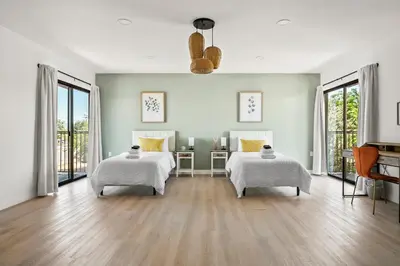 a white room with two beds and windows at Luxury 6BR Retreat Fast WIFI, Dedicated Workspaces in Hesperia