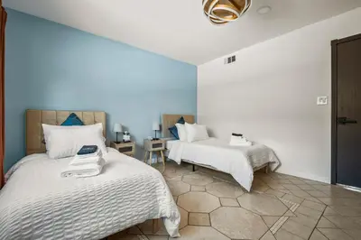 two beds in a room with blue walls at Luxury 6BR Retreat Fast WIFI, Dedicated Workspaces in Hesperia