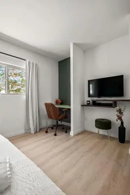 a bedroom with a bed and a desk and a television at Luxury 6BR Retreat Fast WIFI, Dedicated Workspaces in Hesperia