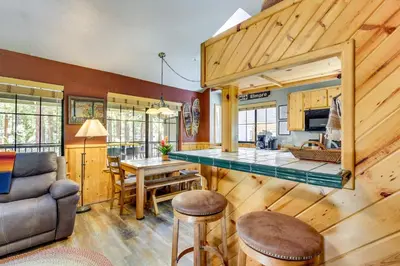 a kitchen and living room with a table and a couch at Central Big Bear Lake Retreat with Private Hot Tub! in Big Bear Lake