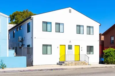 a white house with yellow doors on a street at Sunny Studio in the Heart of Venice - B in Los Angeles