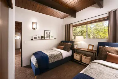 a bedroom with two beds and a window at Large A-Frame Cabin (9 Beds, AC, + Lake Access) in Lake Arrowhead