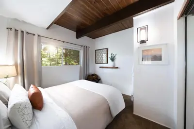 a bedroom with a white bed and a window at Large A-Frame Cabin (9 Beds, AC, + Lake Access) in Lake Arrowhead