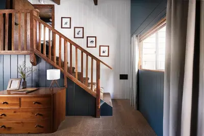 a room with a staircase and a dresser with a desk at Large A-Frame Cabin (9 Beds, AC, + Lake Access) in Lake Arrowhead