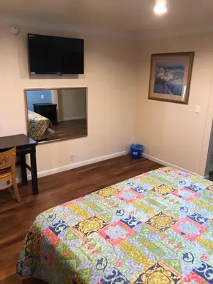a bedroom with a bed and a flat screen tv at Star Motel in Norwalk