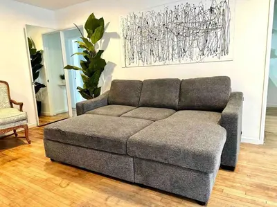 a gray couch in a living room with a chair at Beautiful Bright Condo Steps Away from the Beach in Long Beach