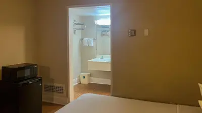 a room with a bathroom with a sink and a microwave at Motel 6 Victorville Green Tree Bvld in Victorville