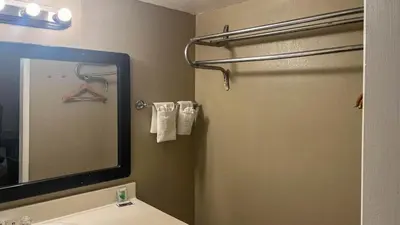 a bathroom with a mirror and a sink and a shower at Motel 6 Victorville Green Tree Bvld in Victorville