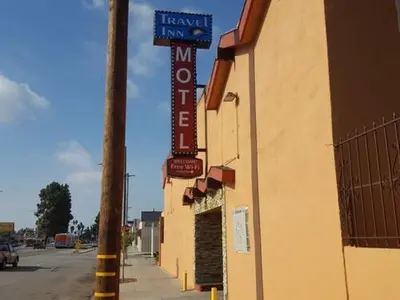 a sign for a hotel on the side of a building at TRAVEL INN MOTEL in Los Angeles
