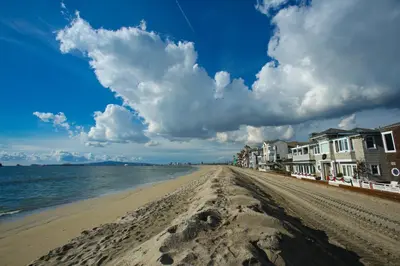 a sandy beach with houses and the ocean at Peninsula Hideaway Apartment • Alamitos Bay in Long Beach