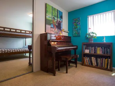 a bedroom with a piano and a bunk bed at Peninsula Hideaway Apartment • Alamitos Bay in Long Beach
