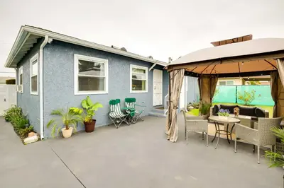 a blue house with a patio with a table and chairs at Centrally Located Compton Retreat Patio and Grills in Compton