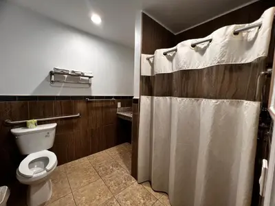 a bathroom with a toilet and a shower curtain at The Patio Motel - Los Angeles, LAX in Gardena