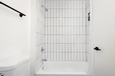 a bathroom with a shower with white tiles at Fenix Hotel Hollywood in Los Angeles