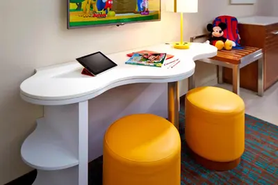 a desk in a hotel room with two orange stools at SpringHill Suites by Marriott at Anaheim Resort Area/Convention Center in Anaheim