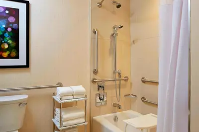 a bathroom with a shower and a toilet and a sink at SpringHill Suites by Marriott at Anaheim Resort Area/Convention Center in Anaheim